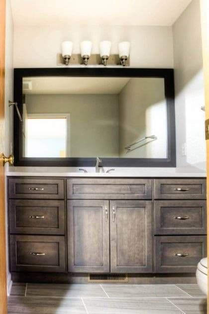A photo of new rustic brown cabinets and white countertops.