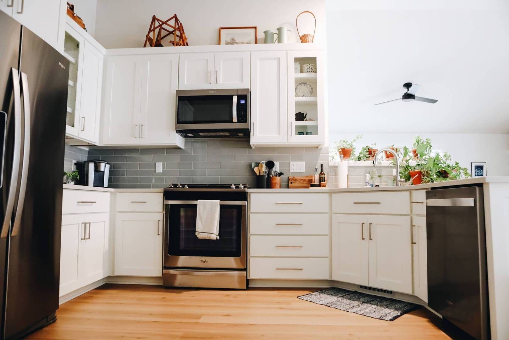 View of a newly remodeled kitchen with white cabinets and tile backsplash